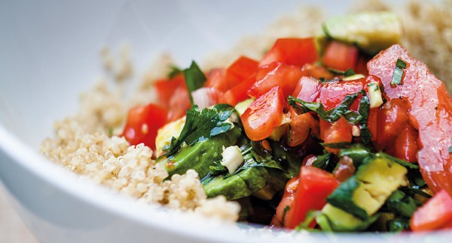 Salade de quinoa, d’avocats et de tomates saupoudrés de persil et de pignons de pin