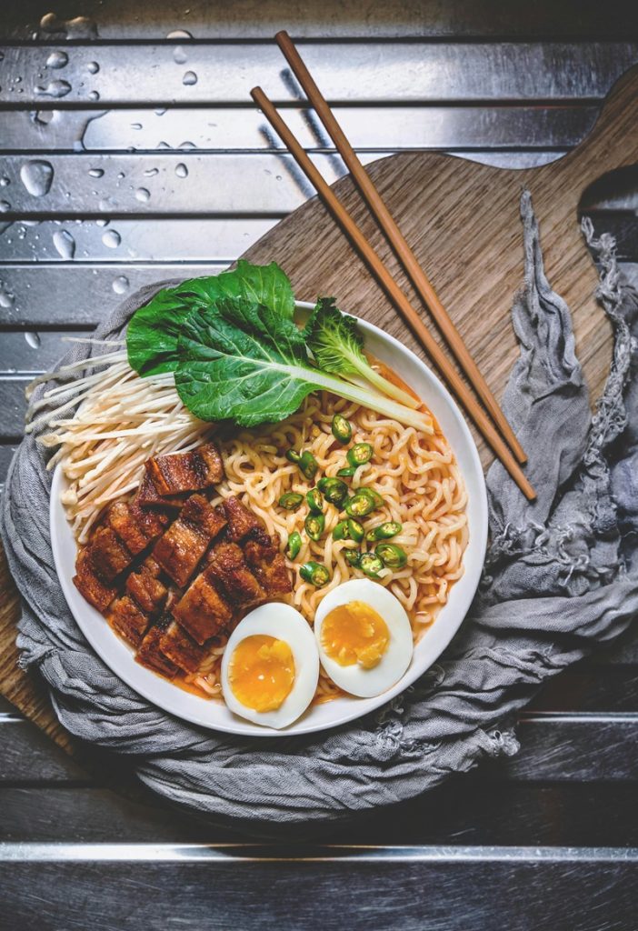 Un bol de nouilles ramen avec du porc des œufs et des feuilles de pakchoï. 