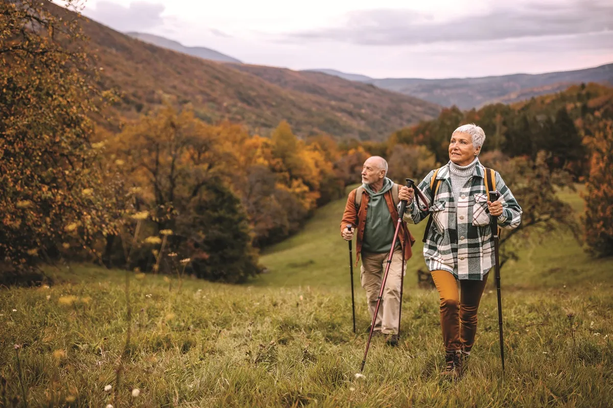 Randonneurs utilisant des bâtons de marche lors d'une randonnée en montagne à l'automne.