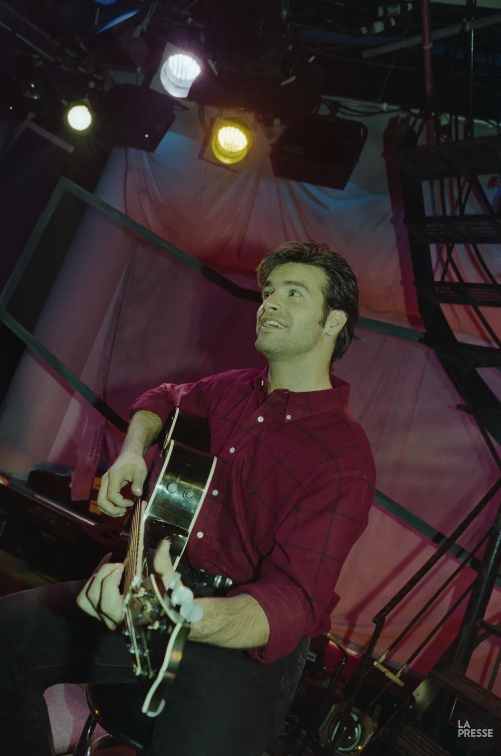 Roch Voisine qui joue de la guitare dans les studios de Musique Plus.